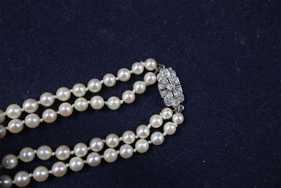 A double strand graduated cultured pearl necklace, with diamond set white metal clasp, 38cm.